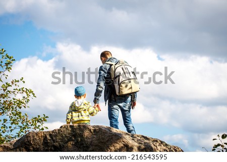 Young father is hiking with 3 year old son