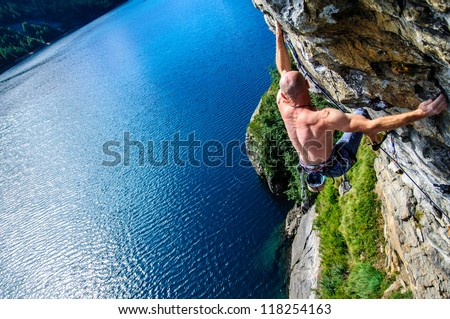 Climber climbing a rock wall above Lake Devero, Northern Italy