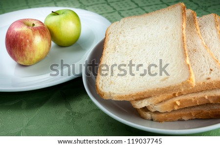 Slices of toast bread and apples on two white plates