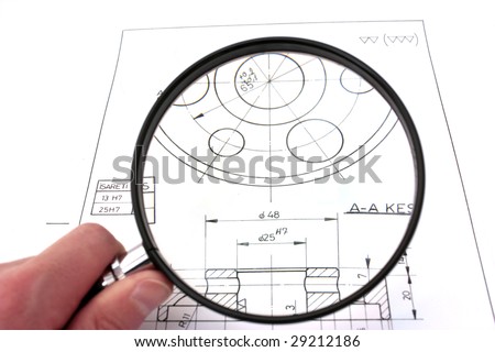 Reviewing technical drawing with magnifying glass. Focus on technical drawing.
