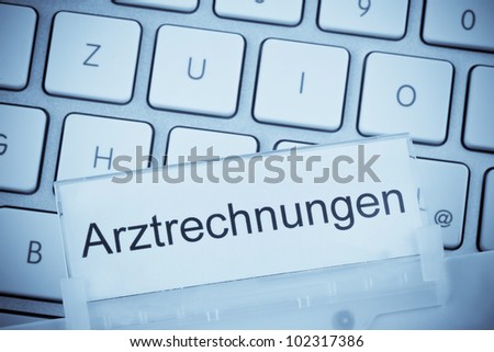 a folder for files in hanging folders in front of a computer keyboard on the topic: medical bills