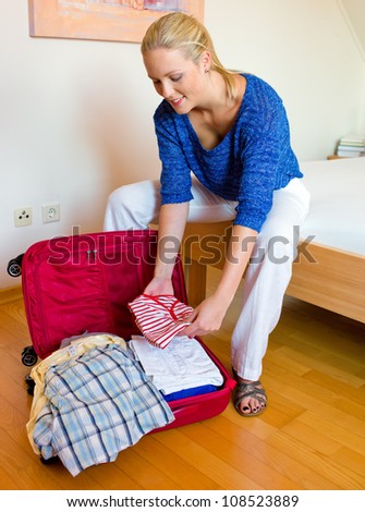 a young woman packing her suitcase for the trip to the holiday.