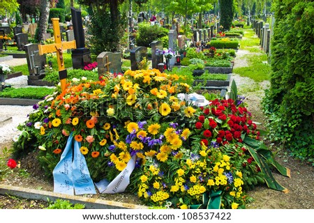in a cemetery, a grave is fresh after a funeral.