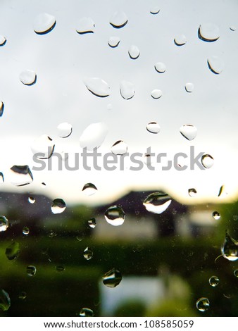 many rain drops during bad weather on a window pane. rainy weather