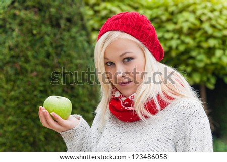 a young woman with an apple. fruits and vegetables are the right vitamins for a cool fall or winter