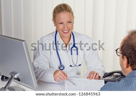 a young female doctor with stethoscope in her doctor\'s office. in an interview with a patient