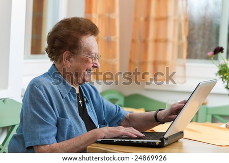 Old woman with a laptop writes e-mail