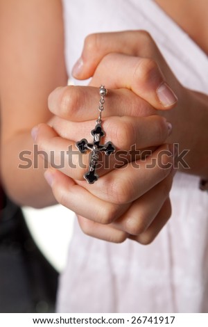 Young girls hands folded in prayer with a cross young girls hands folded in prayer with a cross
