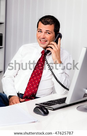 Young business man in the office with a telephone
