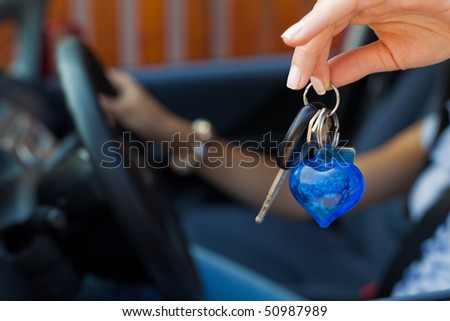 Young woman with new car and car keys