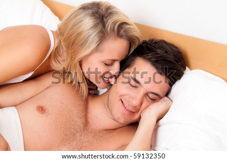 Couple has fun in bed. Laughter, joy and eroticism in the bedroom