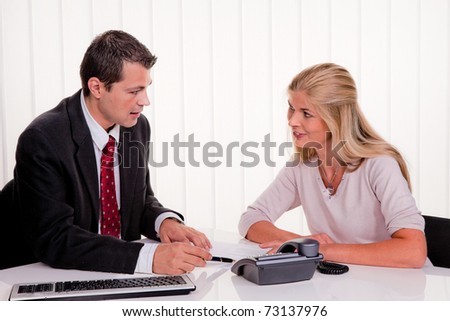 Young woman signs a contract in an office