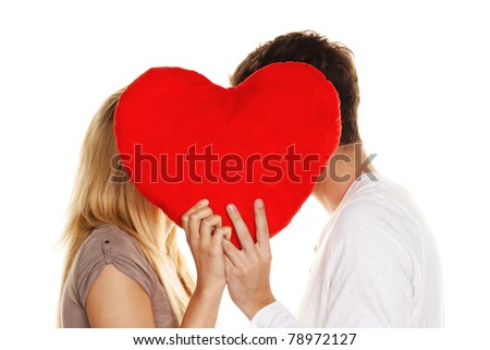 Loving couple kissing behind a heart. Love is beautiful. Secret love
