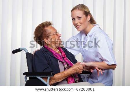 a nurse and an old woman in a wheelchair.