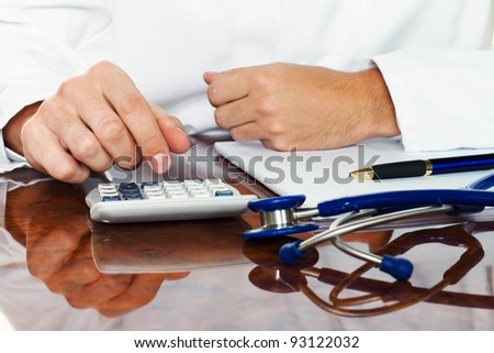 doctor with a calculator. calculation of costs and revenues in physician practice and hospital