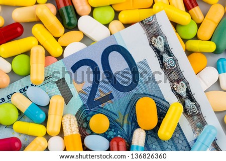 euro banknotes and pills, symbol photo for costs of medications and health insurance.