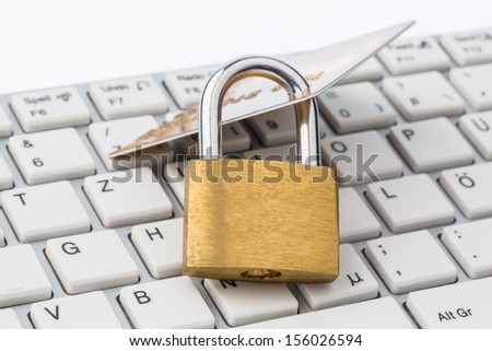 a padlock and a credit card on a keyboard. symbolic photo for secure internet payments, and online crime