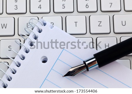 a notepad and keyboard of a computer. write down and save.