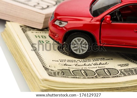 a car stands on dollar banknotes. cost of buying a car, fuel, insurance and other car costs