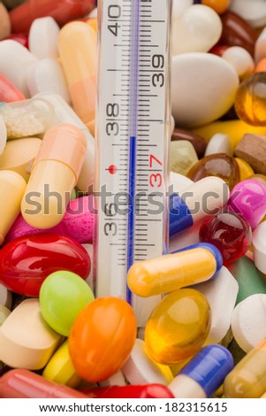 clinical thermometer and tablets, symbol photo for disease and medication