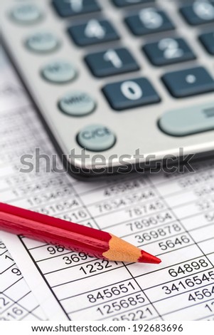 a calculator is on a balance sheet figures are statistics. photo icon for sales, profit and cost.