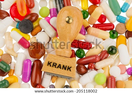 stamp on colorful tablets, symbol photo for illness, sick leave and drugs
