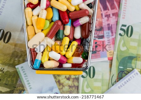 tablets, shopping cart, swiss franc, symbol photo for drugs, health insurance, health care costs