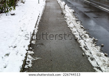 snow on sidewalk and street, symbol for accident risk and photo rÃ?Â?Ã?Â¤umpflicht