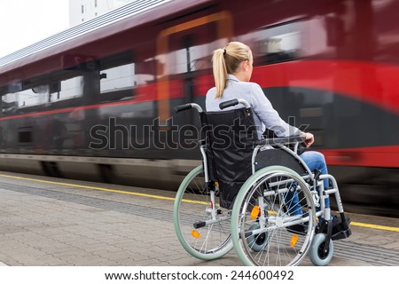 a young woman sitting in a wheelchair at a train station