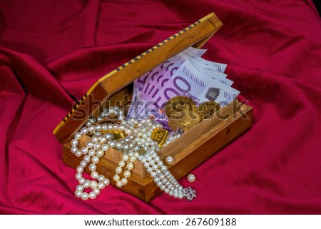 gold coins and bars with decorations on red velvet. photo icon for wealth, luxury, wealth tax.