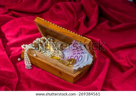gold coins and bars with decorations on red velvet. photo icon for wealth, luxury, wealth tax.
