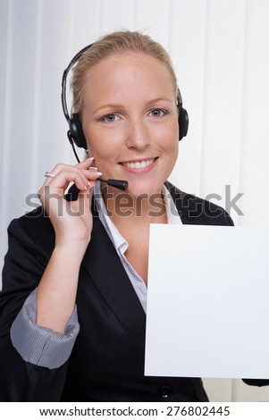 a friendly young woman with headset in customer service on the phone with a customer. friendly hotline employee.
