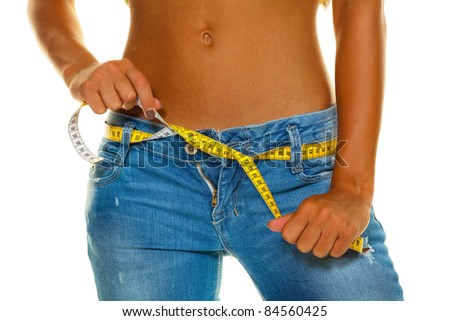 a slender young woman in jeans with a tape measure after a successful diet Stock foto © 