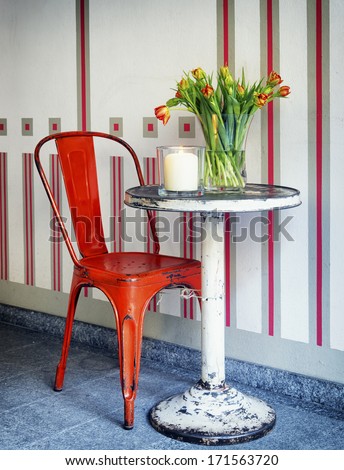 old table and chair with tulips and candle