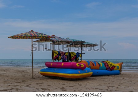 beautiful life-boat umbrella and life jacket on beach for security and fun with blue sky