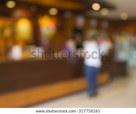 Customers and receptionist at counter in blur motion