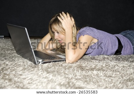 woman laying down and working on a laptop computer at home