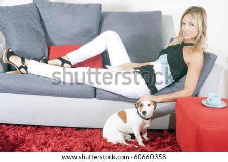 woman at home having tea and playing with her dog
