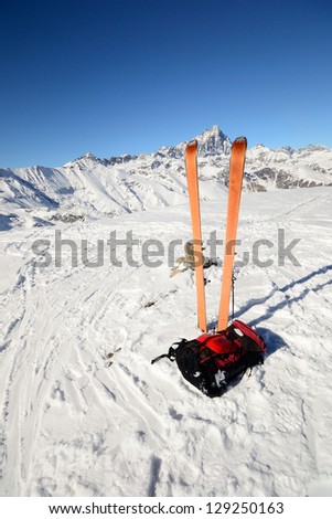 Pair of back country ski (with orange climbing skin) with backpack and avalanche safety tools. Superb view of the majestic M. Viso (3841 m) in the background.