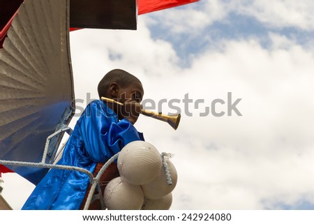 Gonder, Ethiopia - January 19, 2012: Young priest dressed in traditional attire playing the trumpet on a stand during the Timkat holiday, the important Ethiopian Orthodox celebration of Epiphany.