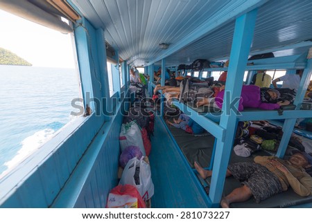 Ampana, Indonesia - August 23, 2014: People sitting or lying on the benches of an obsolete passenger ship while navigating to the Togean (or Togian) Islands, Central Sulawesi, Indonesia.