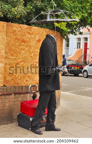 LONDON, UNITED KINGDOM - AUGUST 22:  Human statue without face and umbrella at Portobelllo on August 22, 2009 in London, United Kingdom.