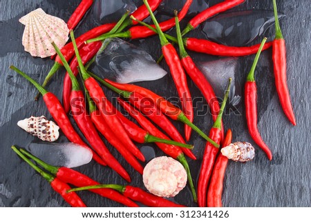 hot red chili pepper on a black stone surface / Hot Red Chili Pepper / Chili Pepper