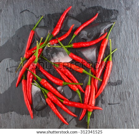 hot red chili pepper on a black stone surface / Hot Red Chili Pepper / Chili Pepper