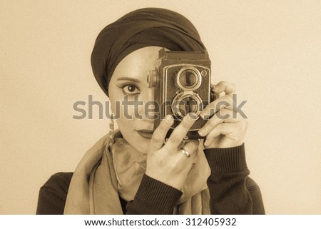 Vintage portrait of  Arabic Young woman with high fashion dark make up wearing veil, scarf and fashion earrings / Veiled Young Woman in dark make up and scarf / Vintage portrait of woman