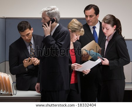 Group of co-workers in crisis meeting in cubicle