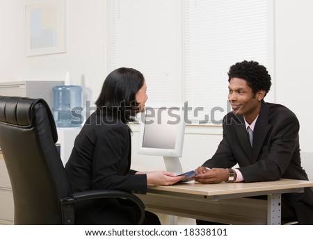 Woman explaining financial brochure to co-worker or customer