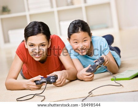 Determined friends having fun using video game controllers to play exciting video game