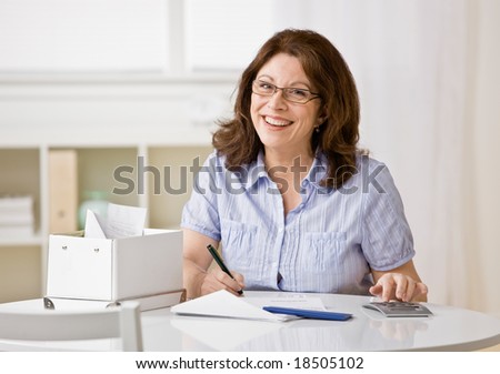 Concentrating woman using calculator to pay monthly bills