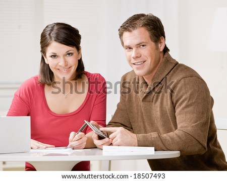 Determined couple using calculator to pay monthly bills